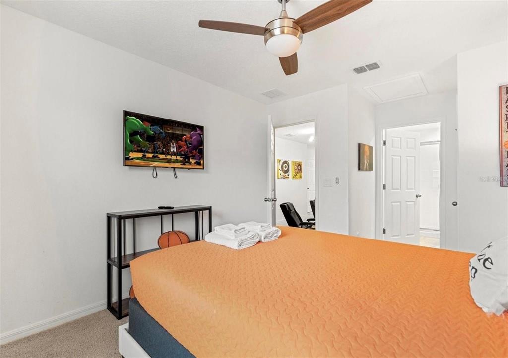 2163 Copper Bell Place Kissimmee, FL 34747 - Photo 25 of 41 a bedroom with a bed and a flat screen tv