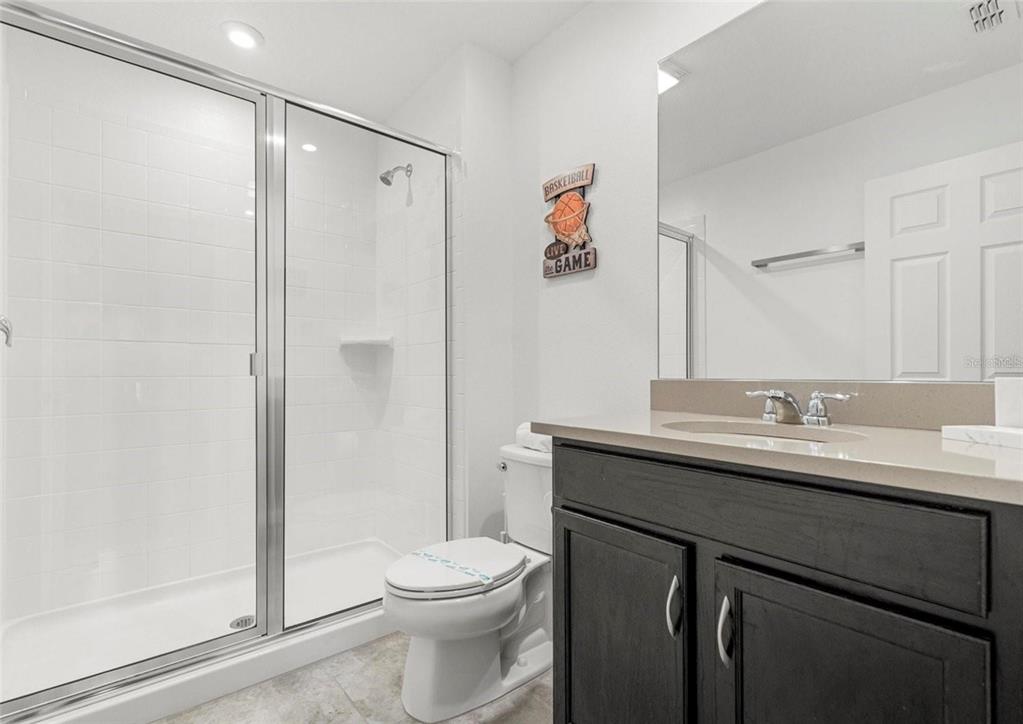 2163 Copper Bell Place Kissimmee, FL 34747 - Photo 26 of 41 a bathroom with a granite countertop sink toilet and shower