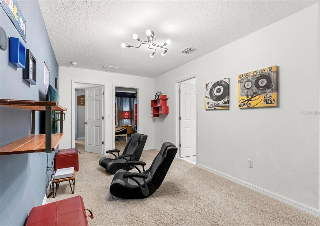 2163 Copper Bell Place Kissimmee, FL 34747 - Photo 29 of 41 a living room with furniture and a chandelier