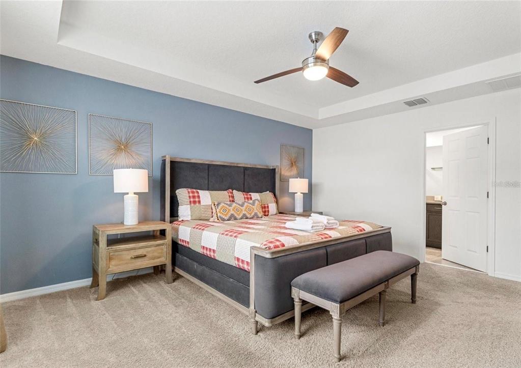 2163 Copper Bell Place Kissimmee, FL 34747 - Photo 33 of 41 a bedroom with a bed and a table