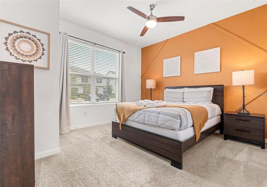 2163 Copper Bell Place Kissimmee, FL 34747 - Photo 5 of 41 a spacious bedroom with a bed and a window