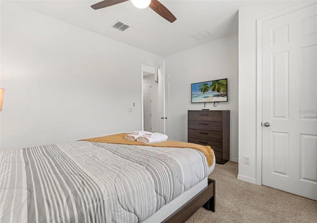 2163 Copper Bell Place Kissimmee, FL 34747 - Photo 6 of 41 a bedroom with a bed and a cabinets