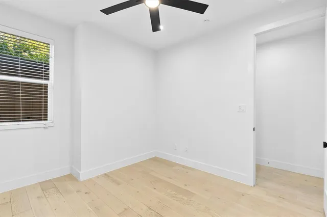 an empty room with a ceiling fan and carpet
