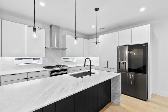 a kitchen with kitchen island a sink stainless steel appliances and cabinets