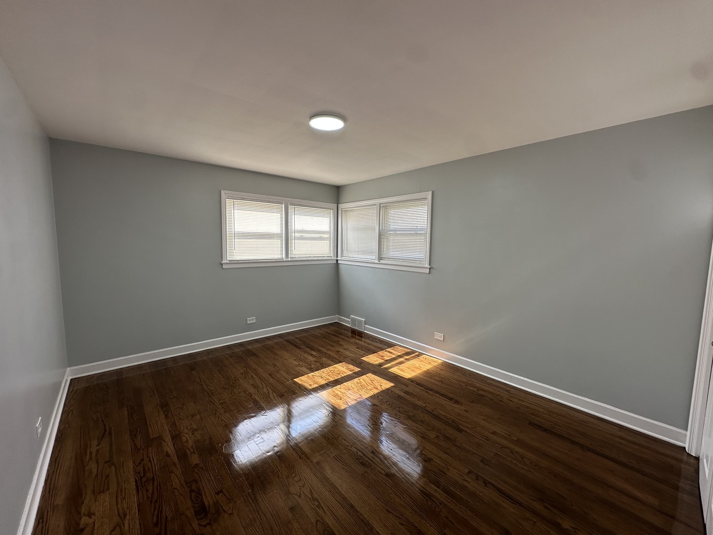 8232 Keating Avenue, Unit 1 Skokie, IL 60076 - Photo 14 of 21 an empty room with wooden floor and windows