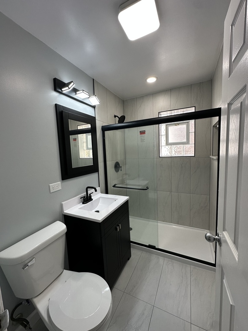 8232 Keating Avenue, Unit 1 Skokie, IL 60076 - Photo 16 of 21 a bathroom with a sink vanity mirror and toilet