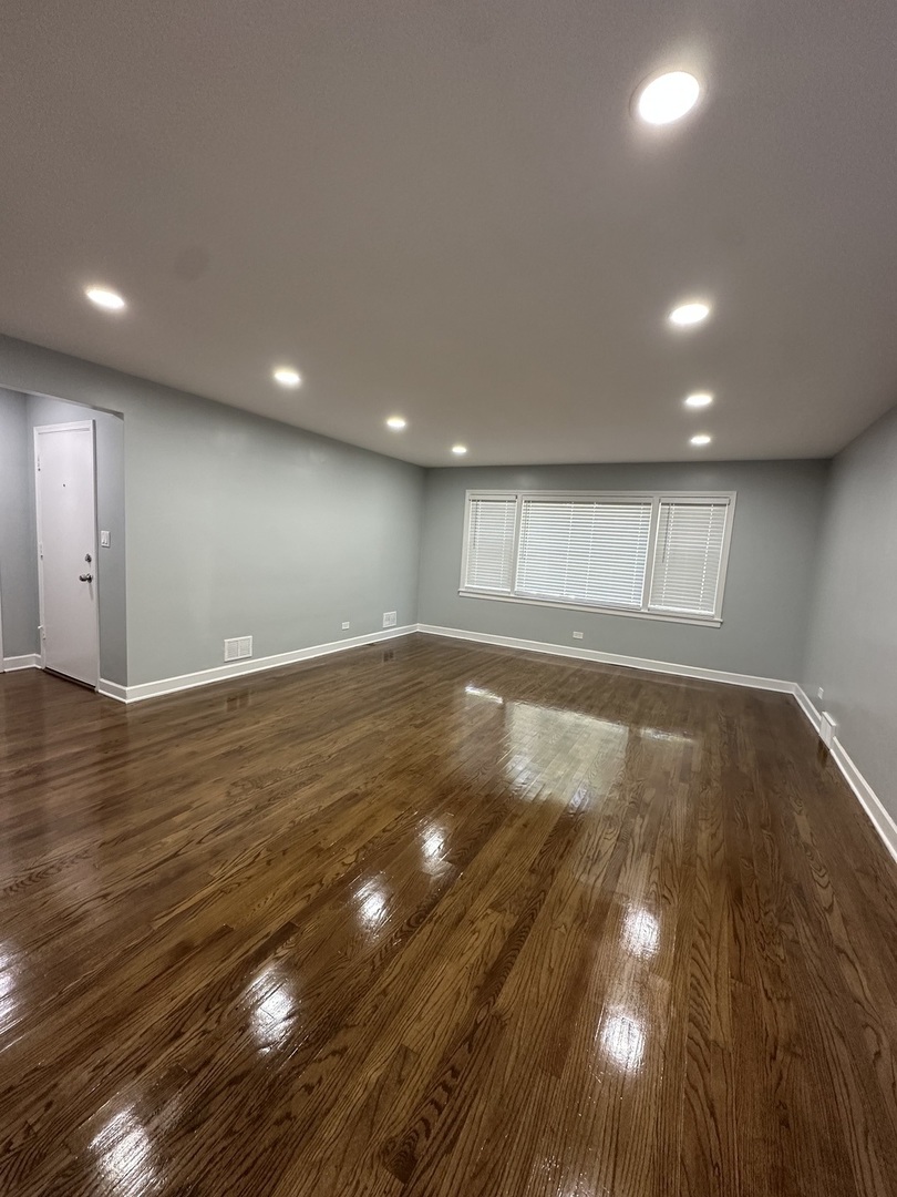 8232 Keating Avenue, Unit 1 Skokie, IL 60076 - Photo 5 of 21 a view of an empty room with wooden floor and a window