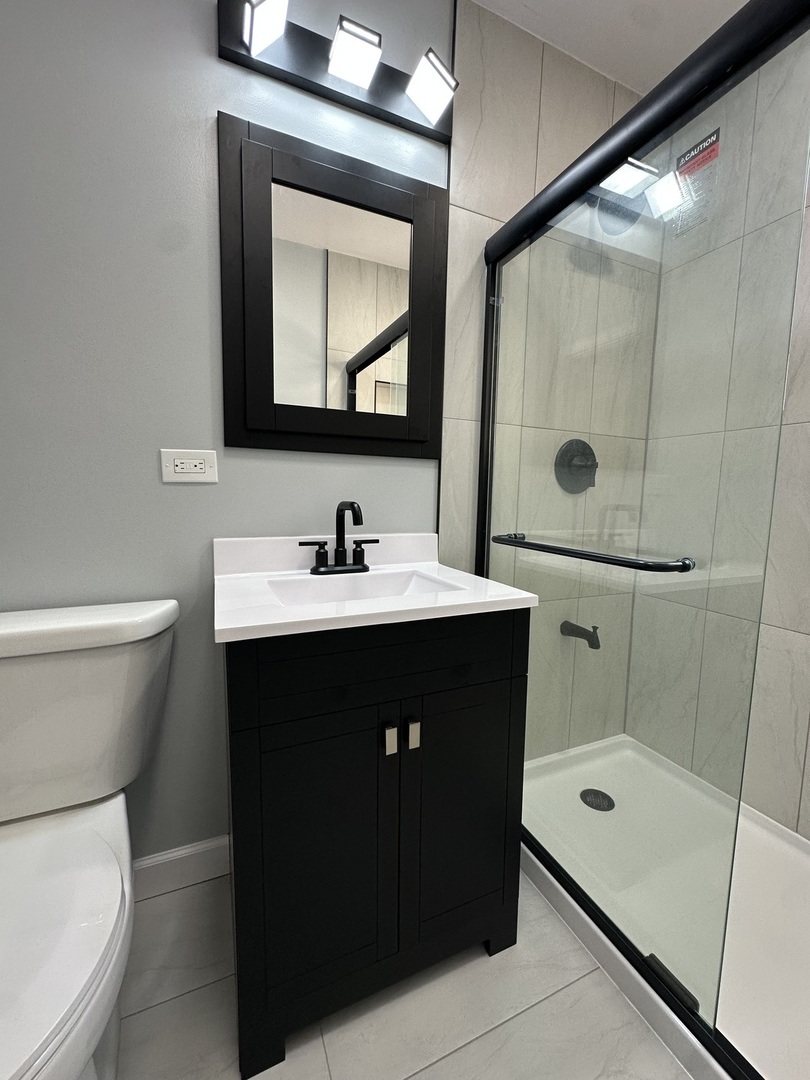 8232 Keating Avenue, Unit 1 Skokie, IL 60076 - Photo 6 of 21 a bathroom with a sink vanity mirror and toilet