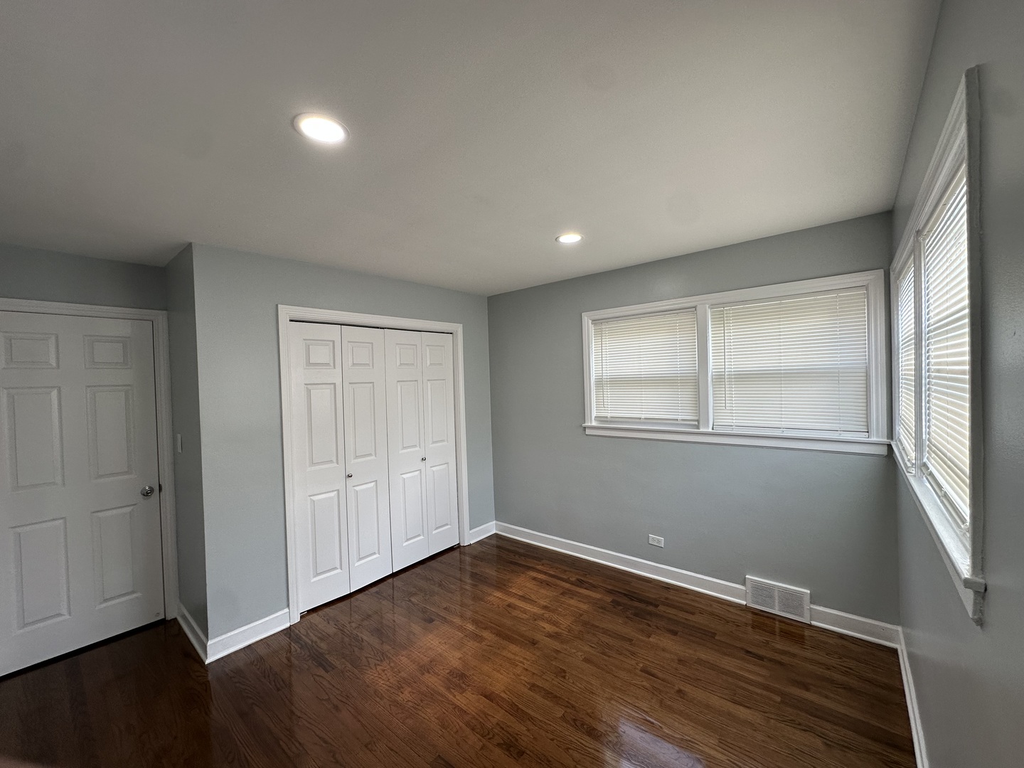 8232 Keating Avenue, Unit 1 Skokie, IL 60076 - Photo 10 of 21 an empty room with wooden floor and windows