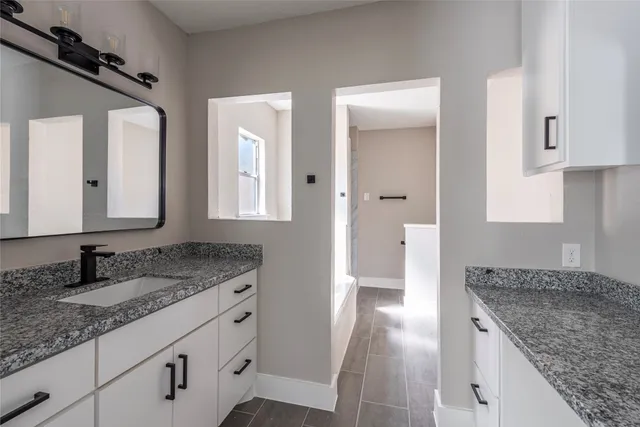 a bathroom with double sink and a granite counter tops