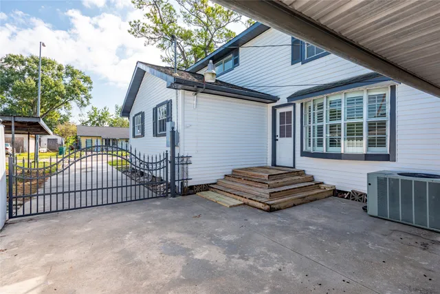 a view of a house with wooden fence and a large tree