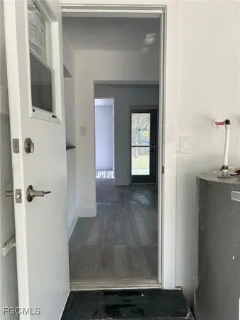 a view of a hallway with wooden floor and a bathroom
