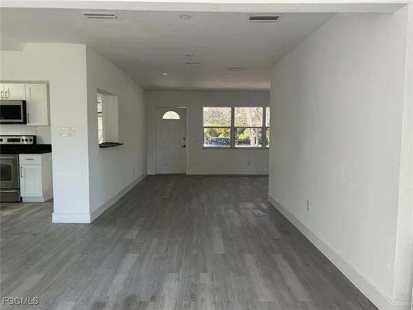 a view of empty room with wooden floor and window