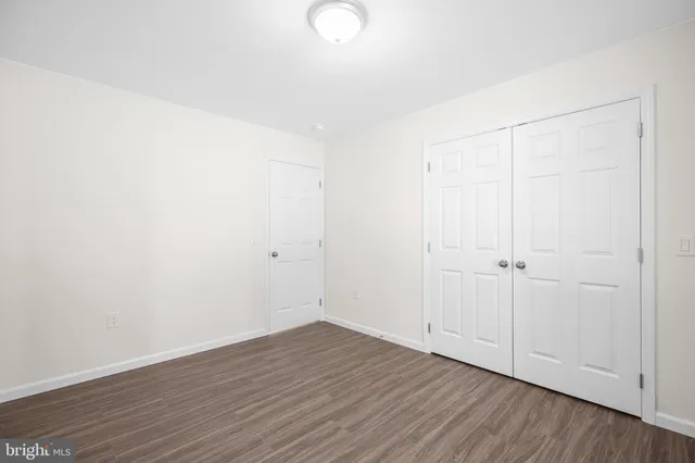 an empty room with wooden floor and a ceiling fan