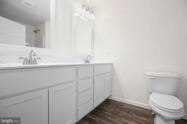 an empty room with wooden floor and a ceiling fan