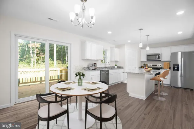 a view of a dining room with furniture a chandelier and wooden floor