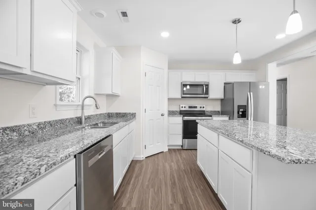 a bathroom with a granite countertop sink a large mirror and a shower