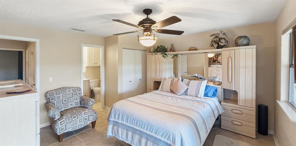 3037 Hells Gate Loop, Unit C208 Strawn, TX 76475 - Photo 17 of 24 a bedroom with a bed and a chandelier
