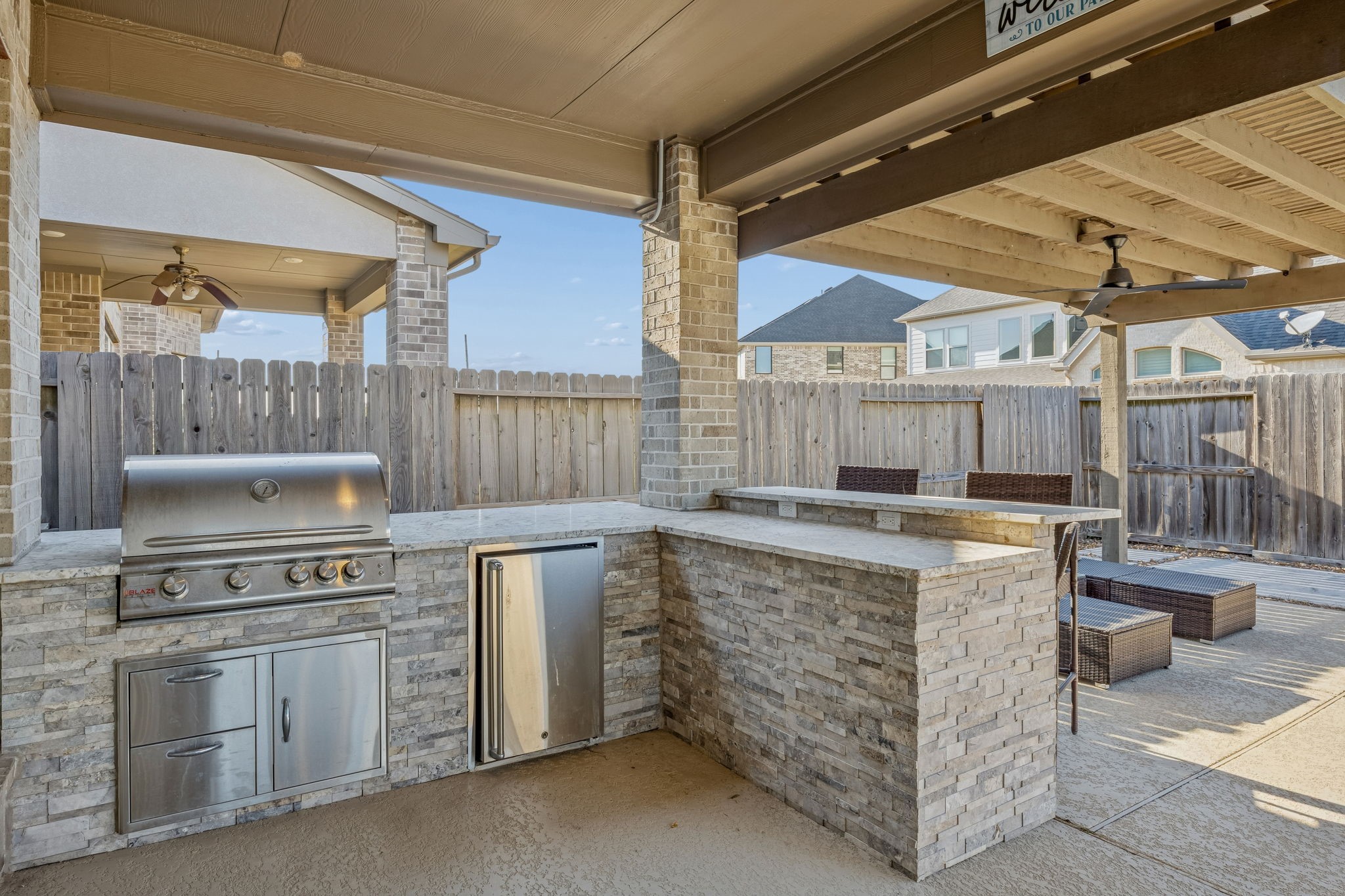28706 Casen Ranch Lane Fulshear, TX 77441 - Photo 22 of 31 Culinary excellence extends outdoors with this premium summer kitchen featuring a high-end gas grill, stainless steel storage, and large countertops.