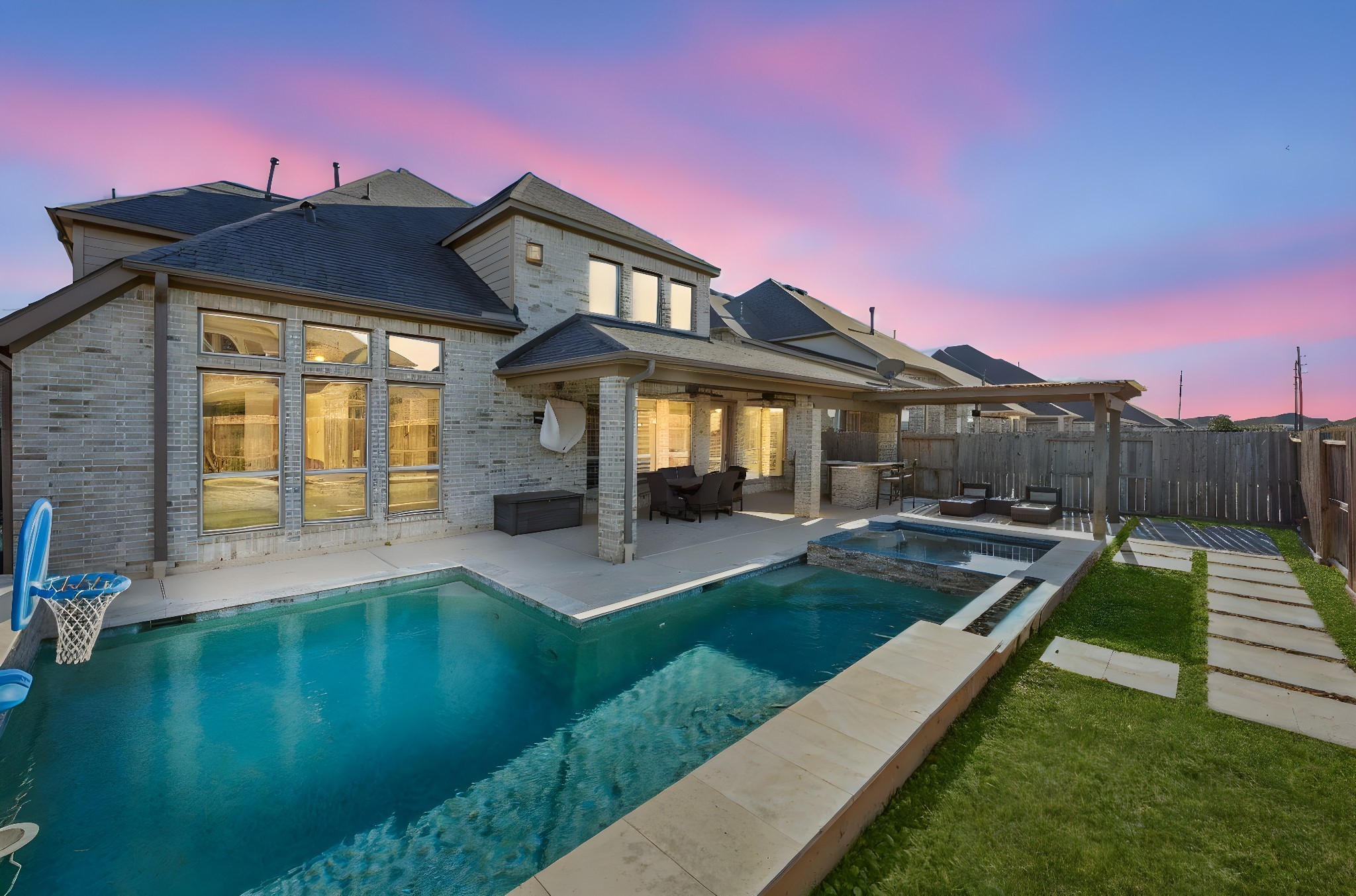 28706 Casen Ranch Lane Fulshear, TX 77441 - Photo 24 of 31 Resort-style backyard retreat featuring a heated gunite pool and spa with convenient smartphone controls, complemented by a spacious covered patio and pergola lounge area—perfect for relaxing evenings, weekend entertaining, and enjoying your own private outdoor oasis.