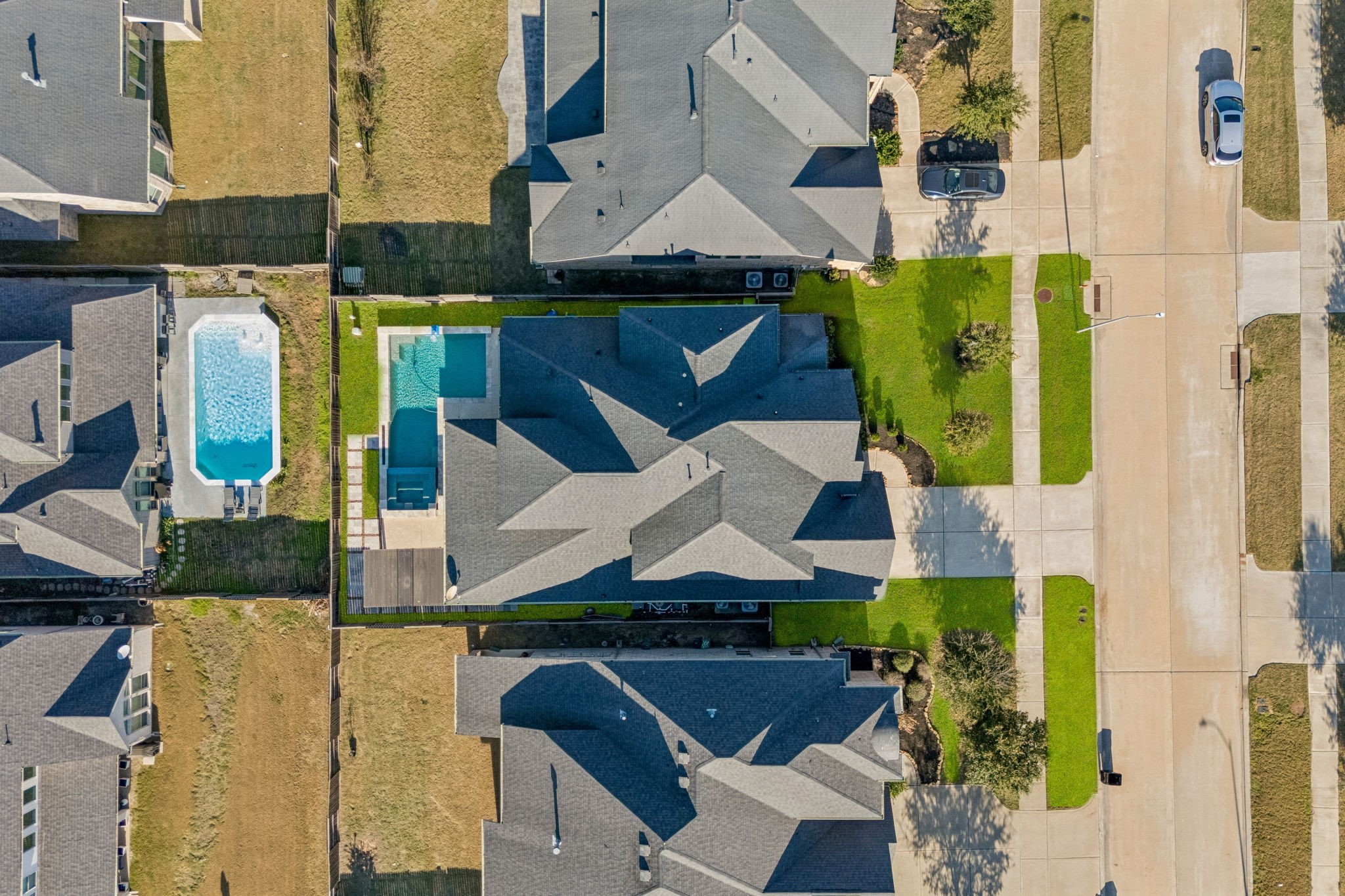 28706 Casen Ranch Lane Fulshear, TX 77441 - Photo 25 of 31 This aerial perspective highlights the home's impressive 7,514-square-foot lot and its thoughtful placement within the community. From this vantage point, you can appreciate the complete layout of the 28706 Casen Ranch Lane estate, from the large front lawn to the resort-style backyard oasis and pool.
