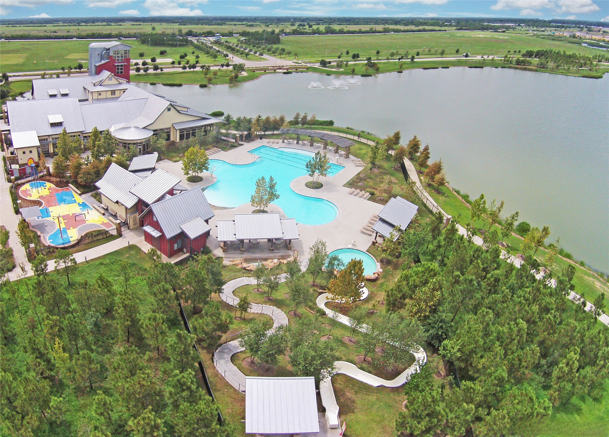28706 Casen Ranch Lane Fulshear, TX 77441 - Photo 28 of 31 Adventure Island at Cross Creek Ranch offers residents a resort-style escape featuring a spacious lagoon pool, interactive splash areas for kids, shaded seating, and scenic views of the surrounding lakes and trails—creating a vibrant outdoor gathering place designed for relaxation, recreation, and year-round family fun.