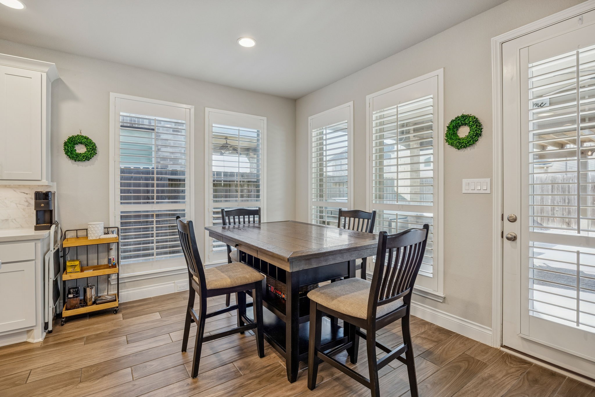 28706 Casen Ranch Lane Fulshear, TX 77441 - Photo 10 of 31 Enjoy morning coffee in this sun-drenched breakfast area wrapped in windows with custom shutters, offering easy access to the covered patio and pool.