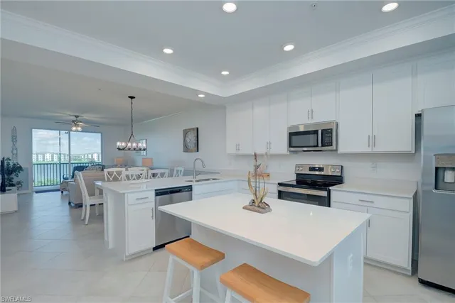a kitchen with stainless steel appliances kitchen island granite countertop a sink a stove a dining table and chairs