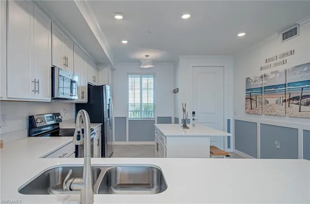 a kitchen with a sink appliances and cabinets