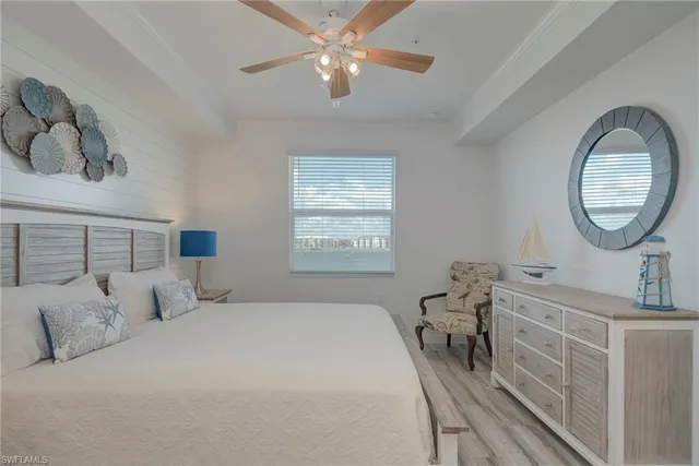 a bedroom with a bed a mirror and paintings on the wall