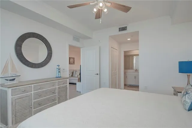 a bedroom with a large bed and a chandelier