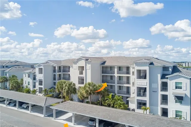 a front view of multiple houses with cars