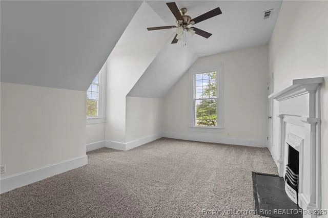a view of an empty room with a fireplace and a window