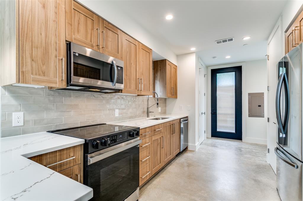 4715 Live Oak Street, Unit 102 Dallas, TX 75204 - Photo 3 of 18 a kitchen with stainless steel appliances granite countertop a stove a sink and a microwave
