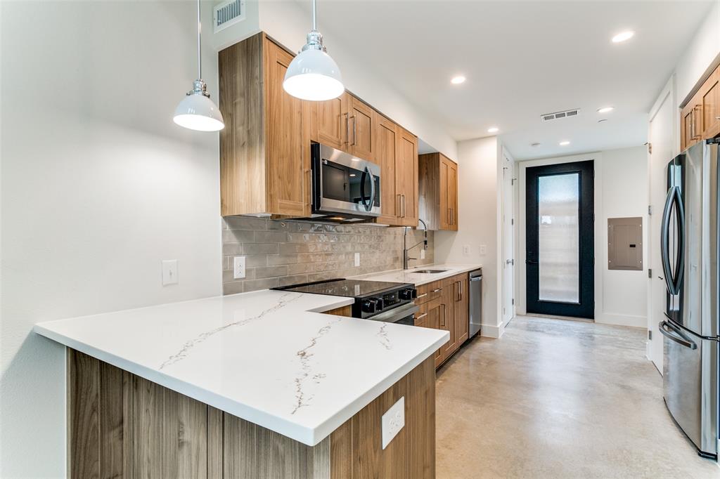 4715 Live Oak Street, Unit 102 Dallas, TX 75204 - Photo 4 of 18 a kitchen with stainless steel appliances a stove microwave and refrigerator