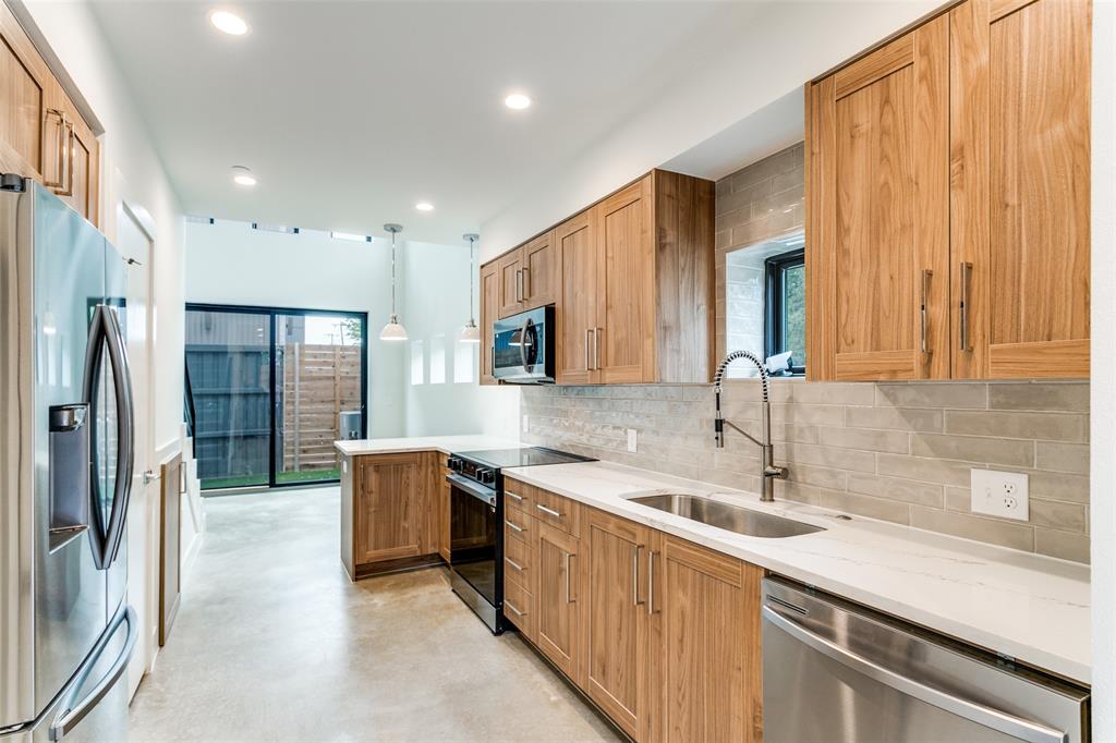 4715 Live Oak Street, Unit 102 Dallas, TX 75204 - Photo 9 of 18 a kitchen with stainless steel appliances granite countertop a sink and a refrigerator