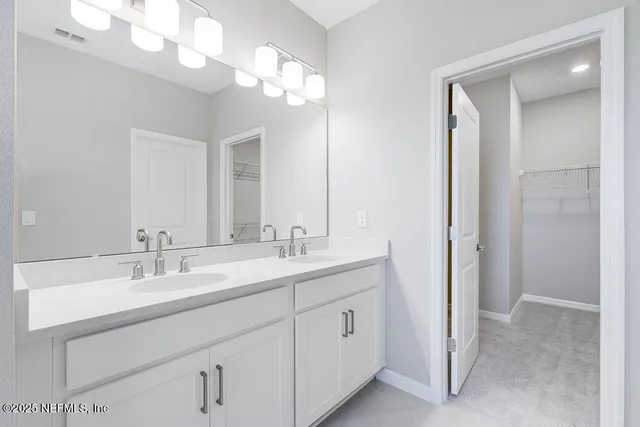 a bathroom with double vanity sink a vanity and a mirror