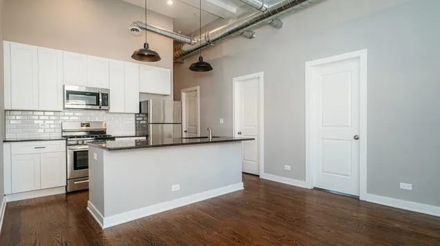 a kitchen with granite countertop a refrigerator stove and sink