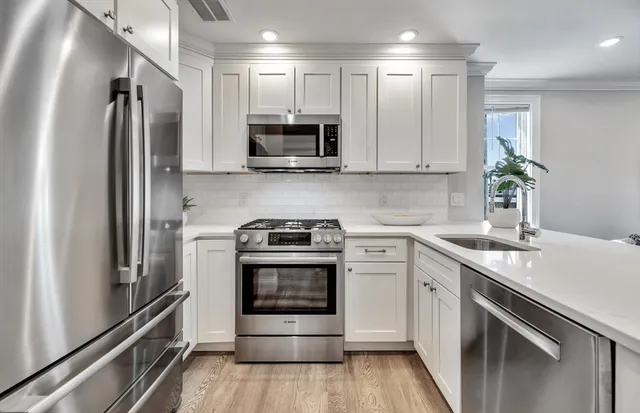 a kitchen with stainless steel appliances a stove microwave and sink