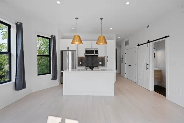 a view of kitchen with stainless steel appliances granite countertop a refrigerator oven a sink and dishwasher with wooden floor