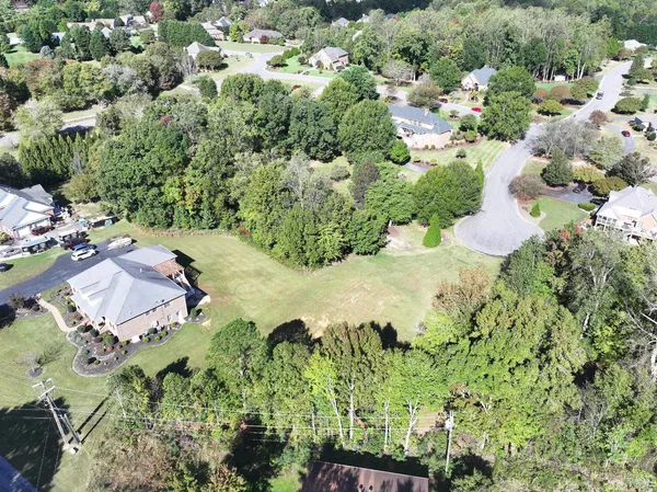 an aerial view of residential house with yard and swimming pool