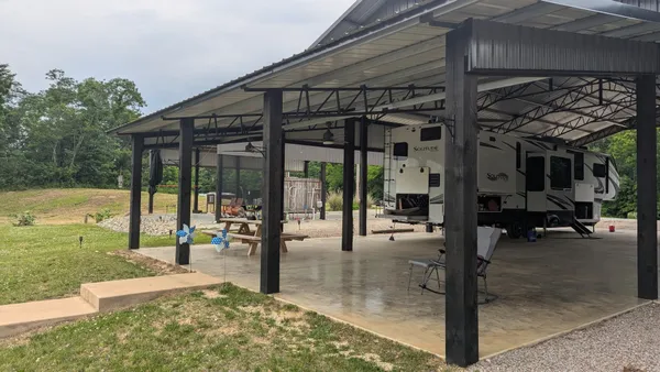 a view of a porch with a table and chairs under an umbrella