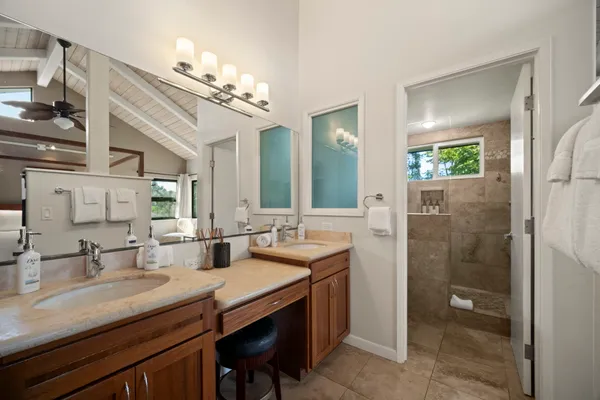 a bathroom with a granite countertop sink a toilet a large mirror and shower