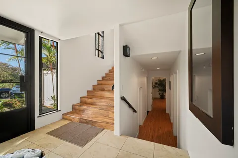 a view of a hallway with wooden floor and staircase