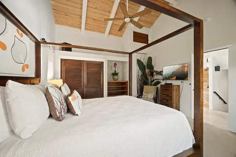 a bedroom with a bed and a large mirror with a flat tv screen