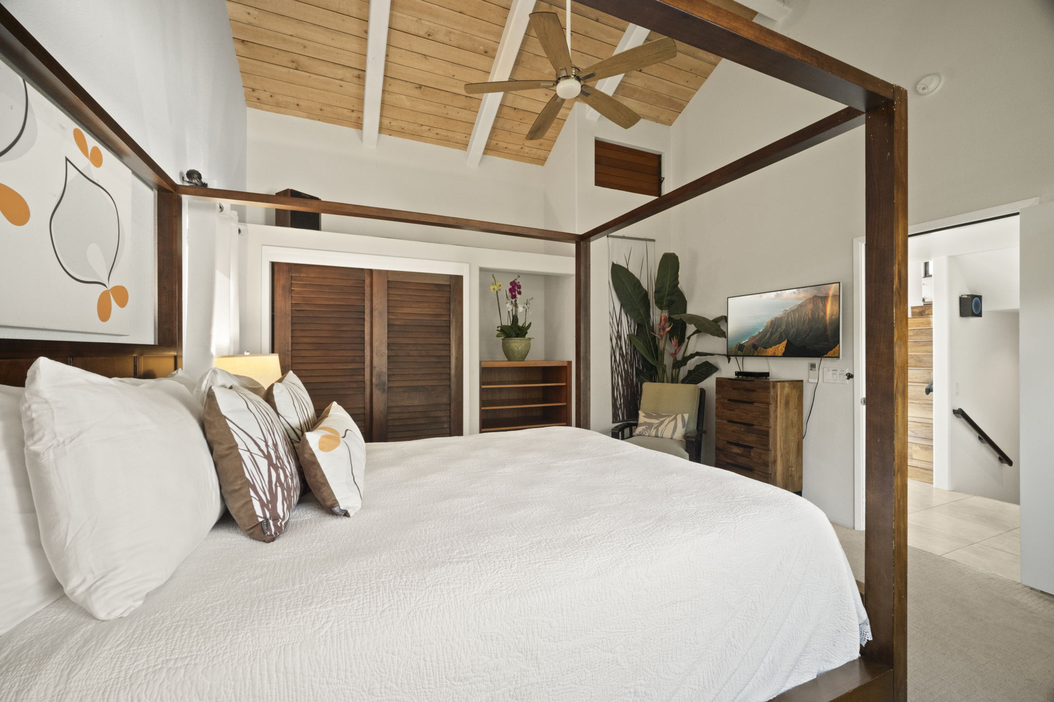 3835 Punahele Road Princeville, HI 96722 - Photo 21 of 30 a bedroom with a bed and a large mirror with a flat tv screen