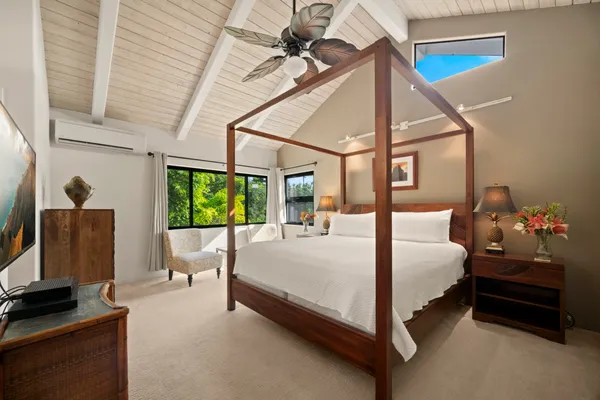 a bedroom with a bed and large windows