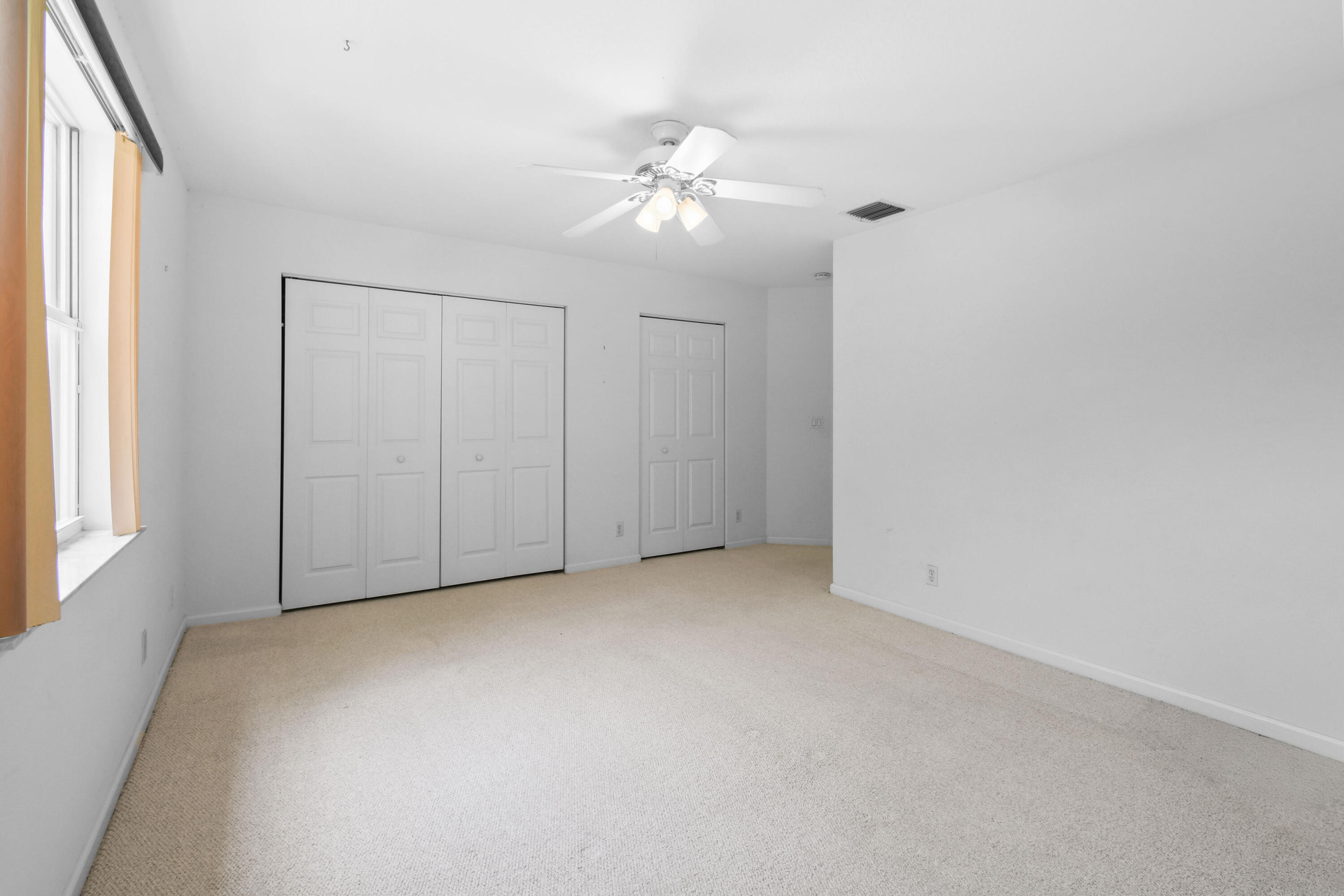 575 Scrubjay Lane Jupiter, FL 33458 - Photo 32 of 60 an empty room with a window and a chandelier fan