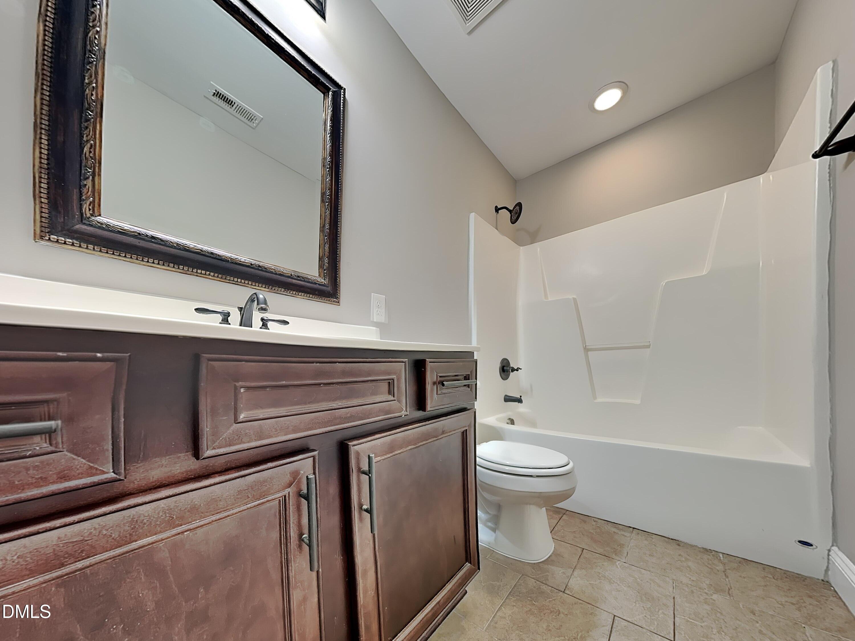 161 Summit Overlook Drive Clayton, NC 27527 - Photo 18 of 25 a bathroom with a sink a toilet a mirror and shower