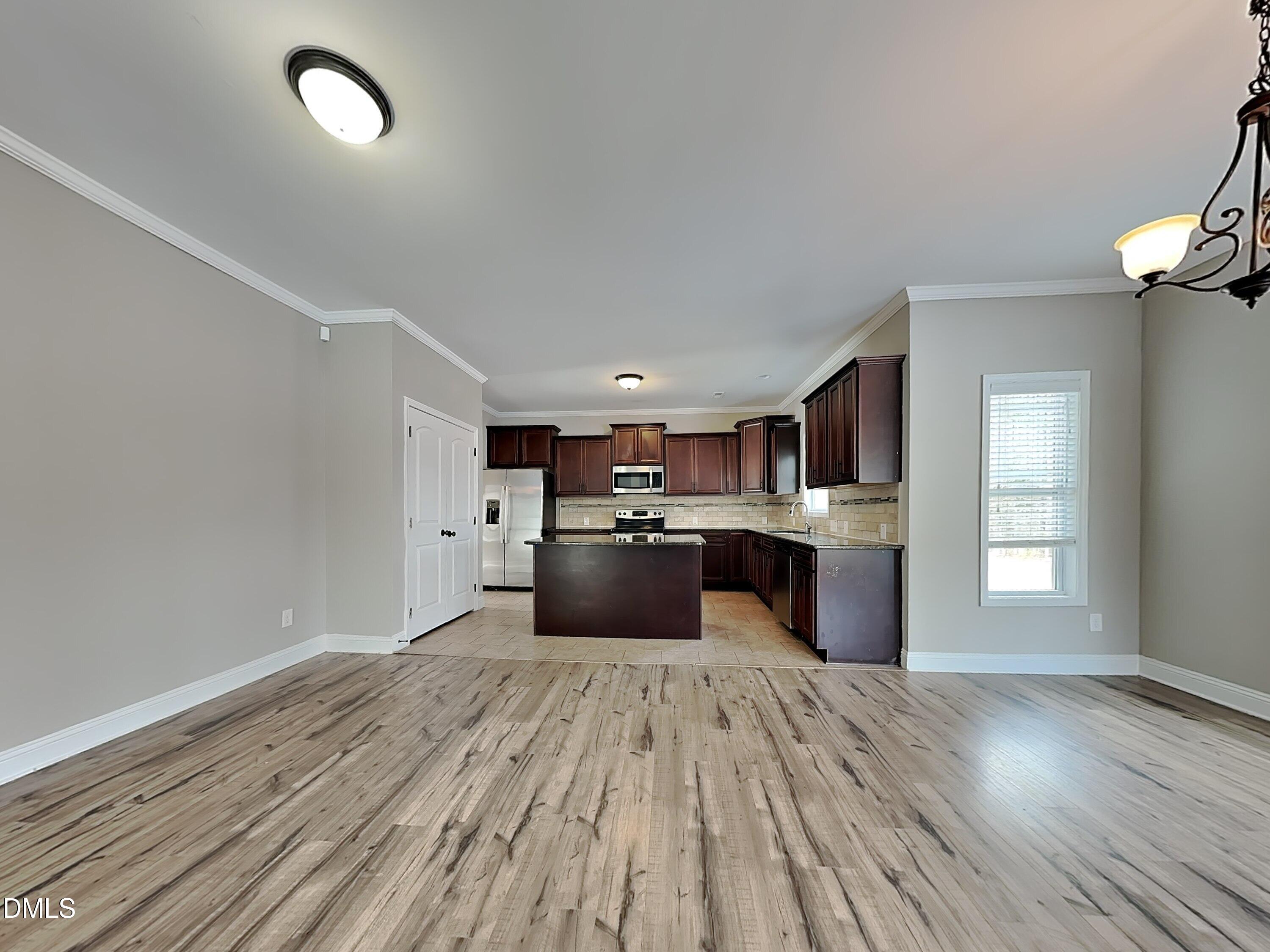 161 Summit Overlook Drive Clayton, NC 27527 - Photo 4 of 25 a large kitchen with a wooden floor and stainless steel appliances